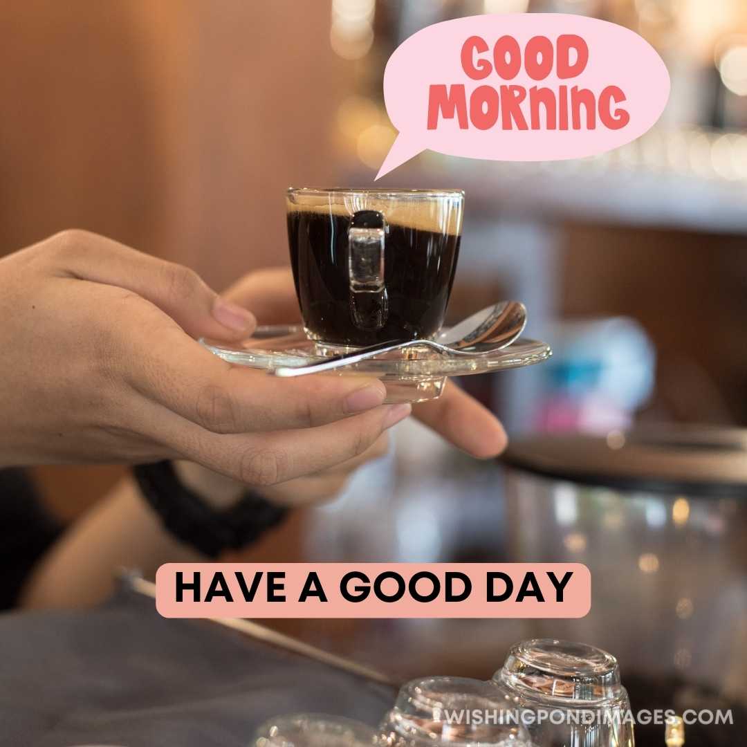 A lady holding a cup of black coffee in small plate with spoon. Good Morning Coffee Images